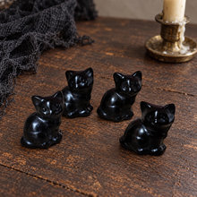 Load image into Gallery viewer, Four 3 cm black obsidian seated cat carvings arranged on worn dark wood