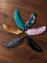 Load image into Gallery viewer, Six carved gemstone feathers arranged on a dark wood background