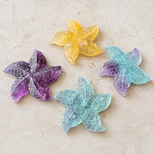 Load image into Gallery viewer, Four colorful Fluorite starfish carvings in yellow, purple, aqua, and aqua-purple on pale stone