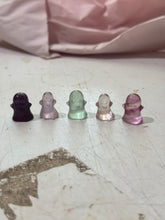 Load image into Gallery viewer, Five tiny fluorite ghost carvings in purple, lavender, pale green, clear, and pink showing the random color range