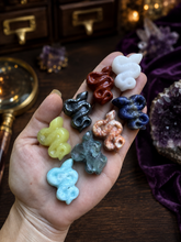 Load image into Gallery viewer, Assorted miniature crystal snake carvings on a dark wood collector's table
