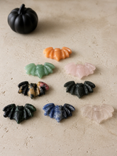 Load image into Gallery viewer, Eight mixed crystal bat carvings lying flat on a cream stone surface
