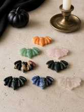 Load image into Gallery viewer, Eight mixed crystal bat carvings lying flat in a Halloween tabletop setting
