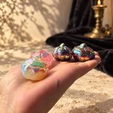 Load image into Gallery viewer, Four iridescent aura pumpkins shown in hand for scale
