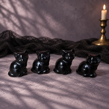 Load image into Gallery viewer, Four 3 cm black obsidian seated cat carvings on a plum gray surface with soft window shadows
