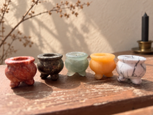 Load image into Gallery viewer, Five assorted miniature stone cauldrons on a wooden ledge with subtle Halloween styling
