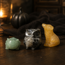 Load image into Gallery viewer, Mini crystal axolotl, owl, and wolf figurines in a Halloween collector's study
