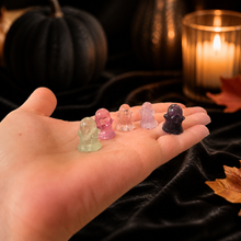 Load image into Gallery viewer, Five colorful mini fluorite ghost carvings resting in a hand for scale against a warm Halloween scene
