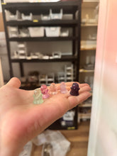 Load image into Gallery viewer, Five colorful mini fluorite ghost carvings resting in a hand for scale
