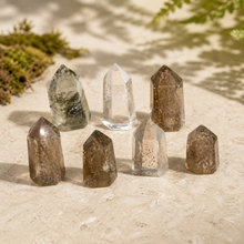 Load image into Gallery viewer, Eight assorted mini included quartz towers with green, smoky, clear, phantom-like, and garden-like inclusions arranged on pale limestone with moss
