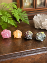 Load image into Gallery viewer, Four assorted 3 cm crystal axolotl carvings on dark wood
