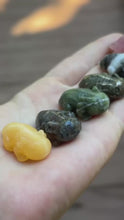 Load and play video in Gallery viewer, Assorted miniature crystal axolotl carvings shown in hand
