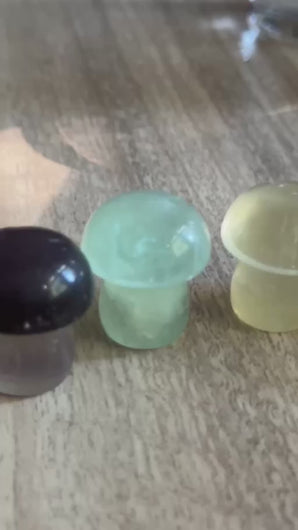 Candy fluorite mushroom carvings fluorescing blue and purple under UV light