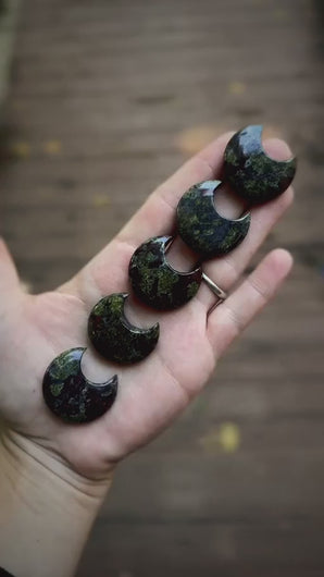 Dragon's blood crescent moon stone carvings in a spooky dark woodland product video