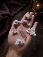 Load image into Gallery viewer, Tombstone Arizona fluorite specimens held in hand with plum fabric and an antique lantern
