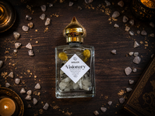 Load image into Gallery viewer, Visionary jasmine perfume oil with rainbow moonstone in a Halloween collector's study
